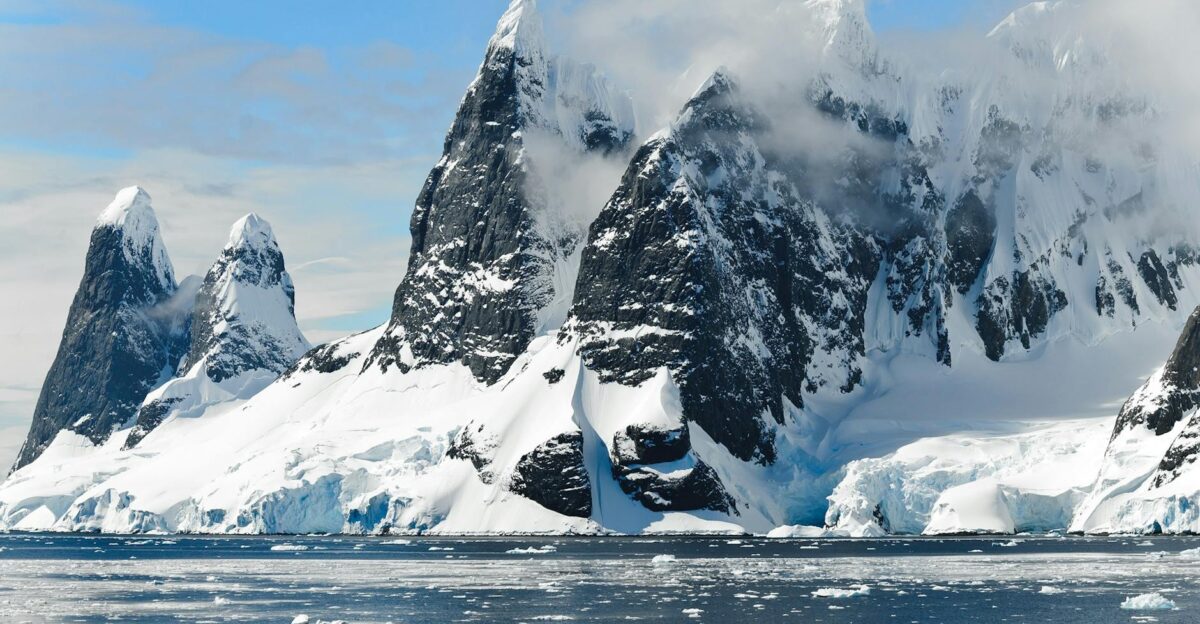 Majestic snowy peaks rise over icy Antarctic waters showcasing untouched nature