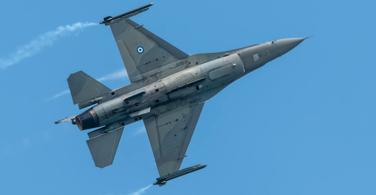 Dynamic shot of a Greek F-16 jet soaring through a clear blue sky showcasing its sleek design