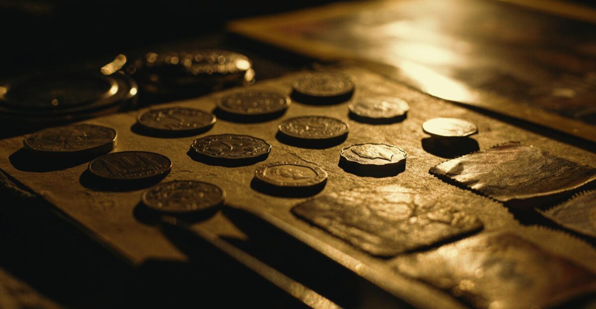 Close-up of antique coins on a table captured with dramatic lighting and rich textures