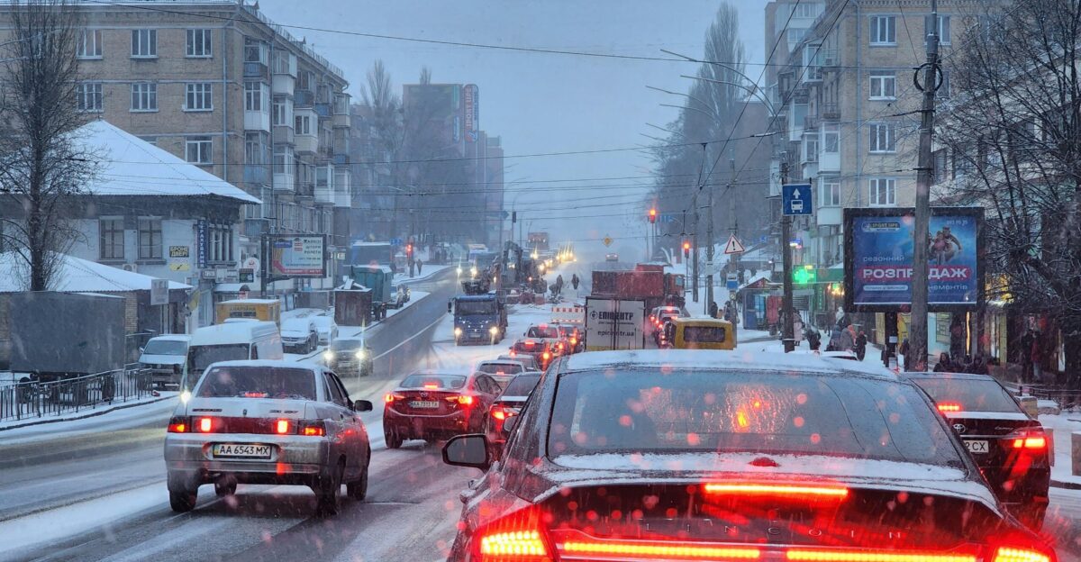a city street filled with lots of traffic on a snowy day
