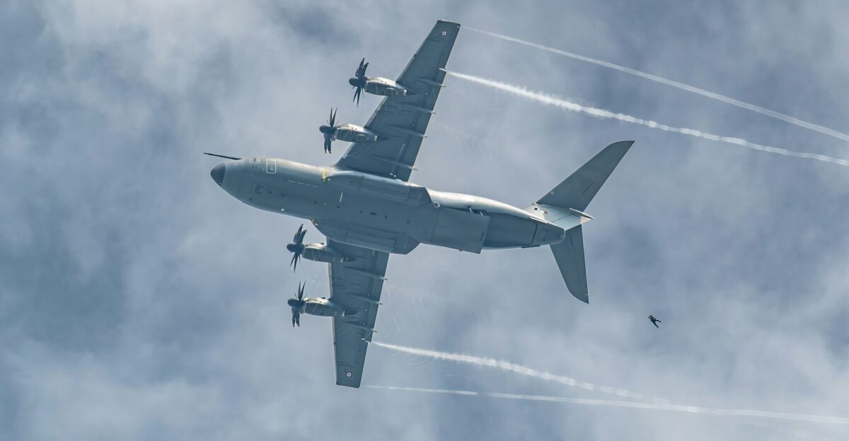 A large airplane flying through a cloudy sky