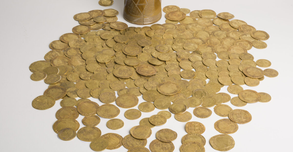 TREASURE CASE 2019 T668 Description A hoard of 266 gold coins dating between AD1610-1727 found within and around a stoneware ceramic vessel during property renovations The coins represent James I AD 1603 - 1625 34 coins Charles I AD 1625 - 1649 42 coins Charles II AD 1660 - 1685 25 coins James II AD 1685 - 1688 14 coins William and Mary AD 1688 - 1694 10 coins William III AD 1695 - 1702 25 coin Anne AD 1702 - 1714 31 coins George I AD 1714 - 1727 84 coin and Joao V of Portugal AD 1706 - 1750 1 coin Vessel A nearly complete 18th century wheel made manganese-mottled salt-glazed earthenware vessel The vessel is a mug or similar though the handle is lost to old worn breaks Projections exist where the hand applied handle extended from the body of the vessel The vessel is circular with thin walls and a slightly flared base A chip is present at the narrow rim The entire vessel is glazed with a streaky and mottled pale honey brown glaze which lightens from the rim to the base Circumferential collars of multiple ridged decoration are present around the base of the vessel as well as approximately 15mm below the rim The decoration was likely created by a comb The upper collar appears to have been combed in two sections upper and lower due to a prominent central depression The lower collar was created by a thicker gauged comb The front of the vessel is decorated with a lotus-like formed of sub-ovate grooved leaves and straight stem A stamped device of the crowned initial AR is present close to the remains of the handle Dimensions Weight 174g Height 89 5mm Depth 81 9mm Diameter rim 72mm Diameter base 73 3mm Wall thickness 2 9mm Coin Catalogue Total Coins 266 Coin 59a was given to a third party before the catalogue was compiled Discussion The hoard was discovered beneath a hard floor during renovations of a private property The contents of the vessel were removed prior to reporting and no record was made of the position of the coins within It has therefore not been possible to determine the stratigraphy of the coin deposition within the vessel The latest coin in the hoard is a 5th bust Guinea of George I which suggests a terminus post quem of 1727 Prior to contacting the Finds Liaison Officer the finder took the hoard to Spink at a coin fair at York Racecourse Spink compiled an initial report and catalogue of the group which was subsequently reviewed and amended Manganese-mottled ceramics were popular form the late 17th century onward though less so by the middle of the 18th century They were often undecorated or bore simple grooved decoration and were commonly stamped with the initials of the ruling monarch No comparable hoards in date or composition are known from Yorkshire Brown Dooley 1971 lists five coin hoards containing over 200 gold coins Batley Buckingham Deposited AD 1633 200 gold coins p 26 EP28 Lewisham London Deposited AD 1645 420 gold coins p 29 EP64 Tunstall Kent Deposited uncertain 614 gold coins p 32 EP126 Long Crendon Deposited uncertain 210 gold coins 846 silver coins p 33 EQ5 Aveton Guiford Devon Deposited uncertain 200 gold coins p 37 GA7 Coins tend to be hoarded during periods of political or economic instability This seems unlikely to be the case with the present example and it may represent personal savings Given the span of monarchs represented there may have been multiple periods of additions Conclusion As all the coins within the hoard are of good quality gold the earliest coins are over 300 years old and all were clearly hoarded as a group the find qualifies as Treasure under the stipulations of the Treasure Act 1996 Acknowledgements Thanks are extended to Rebecca Vickers Finds Liaison Assistant and Luck Dale Durham University Placement Student for their assistance in photographing the group and individual coins Also to Peter Smith PAS volunteer for Photoshopping the individual coin images References Brown I D and Dolley M 1971 Coin hoards of Great Britain and Ireland London Royal Numismatic Society