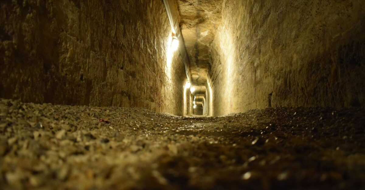 Moody stone tunnel in the Paris Catacombs dimly lit and mysterious