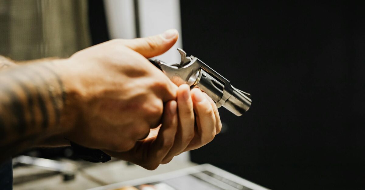 A detailed close-up of a person holding a revolver in an indoor setting Strong focus on hands and firearm