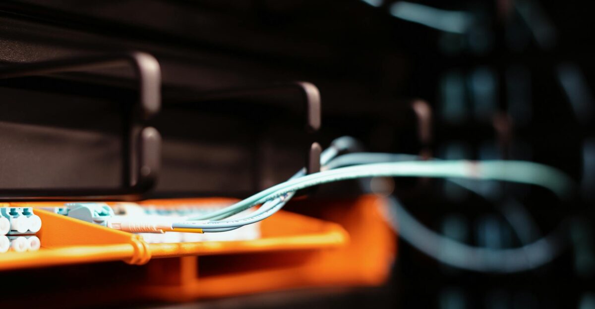 Blue wires connected to contemporary electronic equipment with multiple inputs on blur background