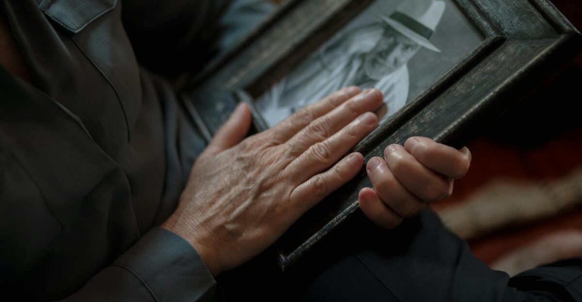 A close-up shot of hands gently holding a vintage framed photograph evoking nostalgia and memories