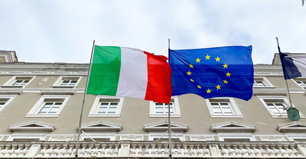 two flags are flying in front of a building