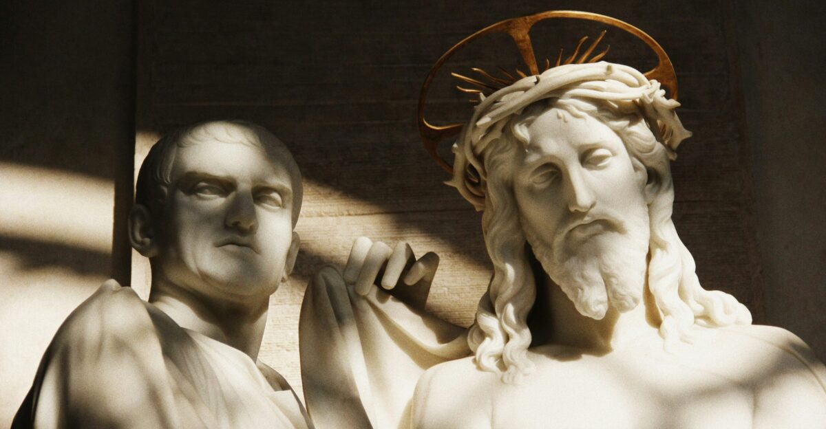 a statue of jesus and a man with a crown on his head