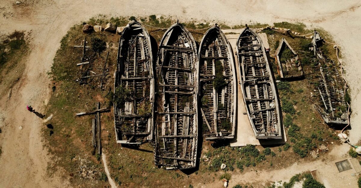 a group of boats sitting on top of a sandy beach