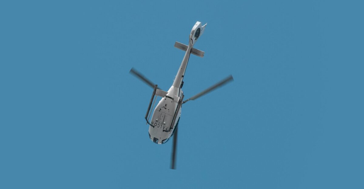 a helicopter flying through a blue sky on a sunny day