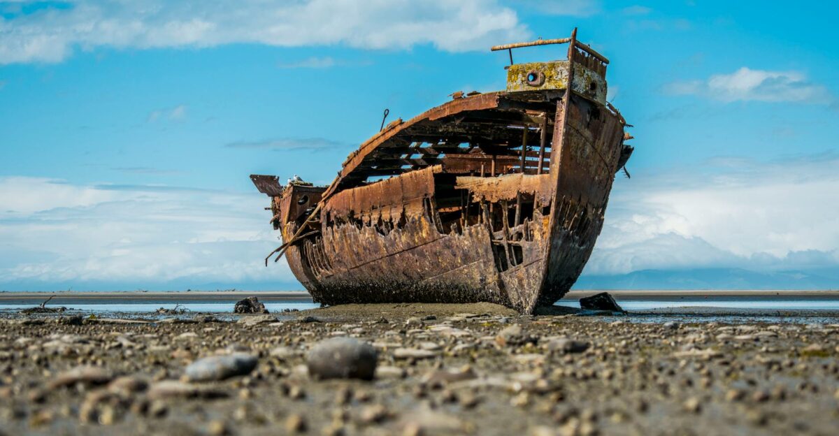 Rusty shipwreck on the beach at Motueka New Zealand under a clear sky