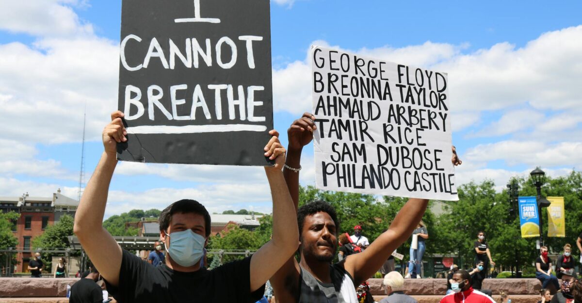 Protesters with signs rally for justice highlighting victims of racial injustice