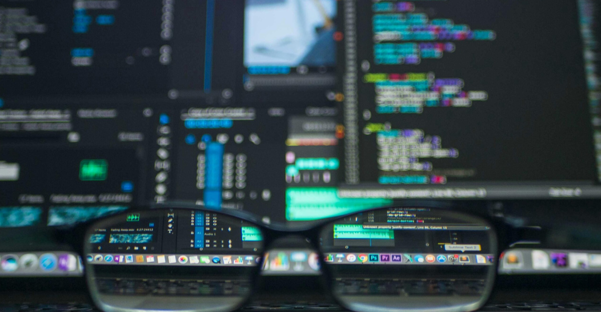 Eyeglasses reflecting computer code on a monitor, ideal for technology and programming themes.