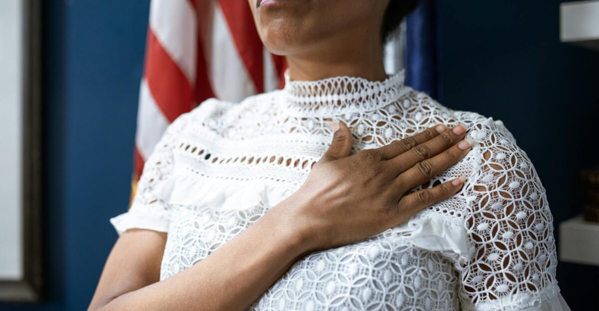 A confident woman in white lace dress pledges allegiance symbolizing leadership and patriotism