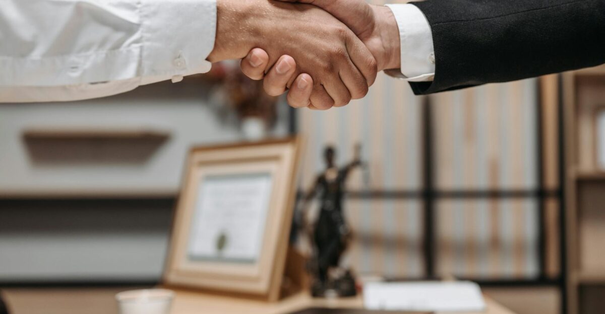 Close-up of a handshake between two professionals in a modern office setting emphasizing partnership and agreement