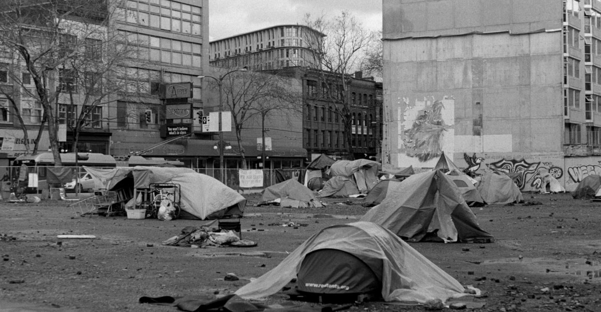 a black and white photo of a homeless camp site