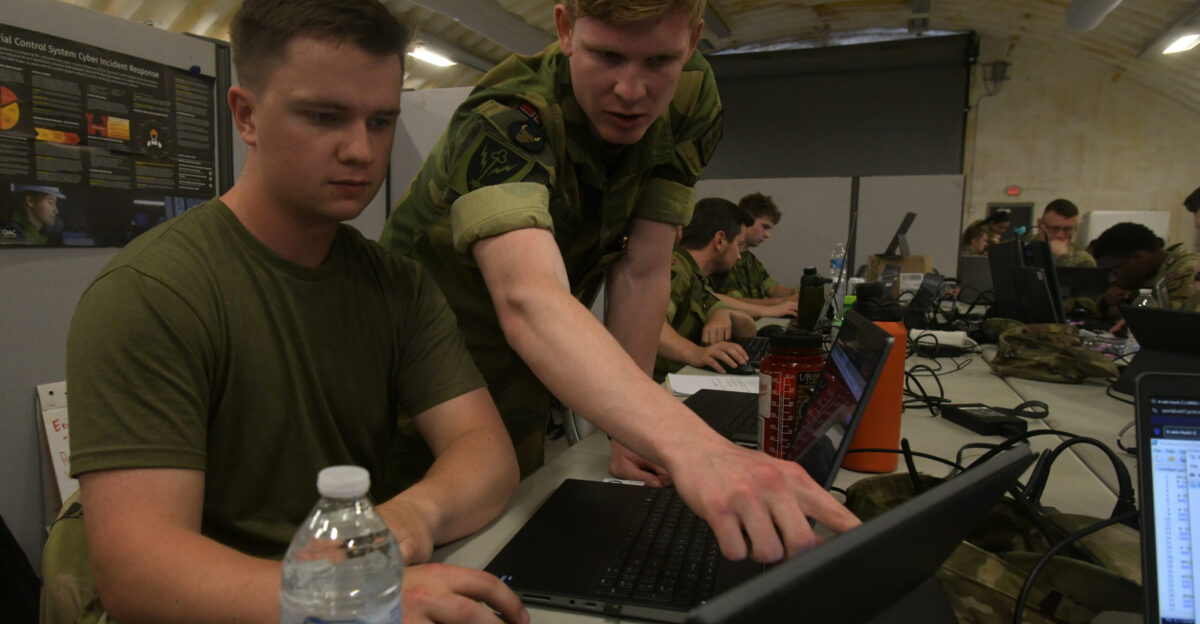 U S Army Sgt Samuel Draeger left a cyber warfare operator with the 177th Cyber Protection Team Minnesota Army National Guard listens as a Norwegian military cyber team member points out suspicious network activity while defending their computer network during exercise Cyber Shield in Virginia Beach Virginia July 9 2025 Hosted by the Virginia National Guard the exercise included more than 900 participants from throughout the U S military and 15 partner nations and focused on safeguarding networks from cyber threats in a scenario geared around protecting critical infrastructure U S Army photo by Sgt 1st Class Jon Soucy